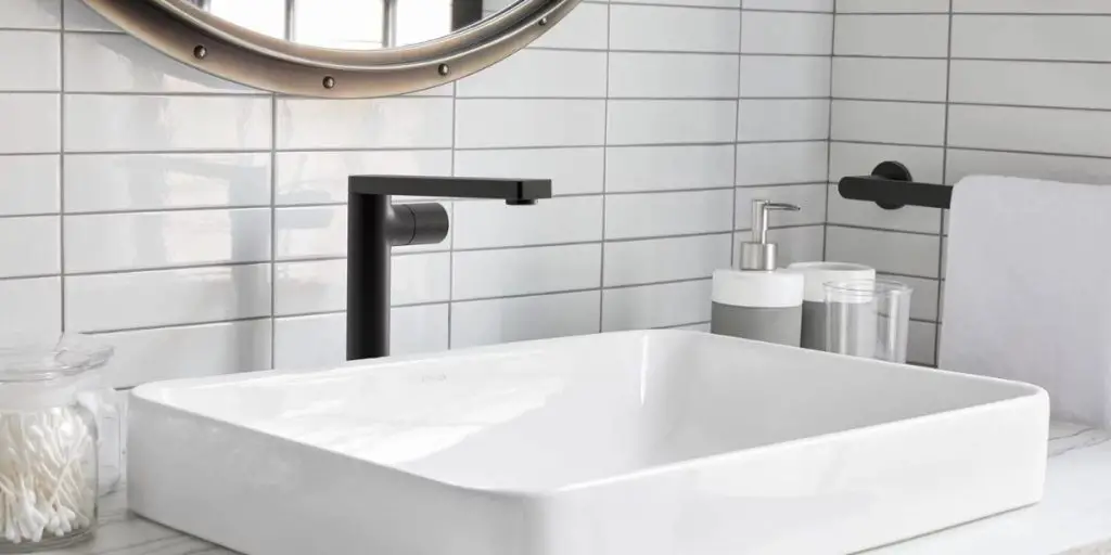 matte black Kohler kitchen faucet on top of white sink