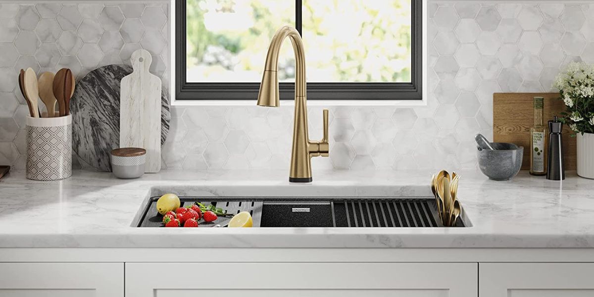 Black granite undermount kitchen sink with gold faucet by Delta